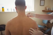 Fisioterapista che esegue l'ago secco sulla spalla del paziente in clinica — Foto stock
