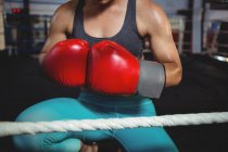 Mid section of female boxer with boxing gloves in boxing ring at fitness studio — Stock Photo
