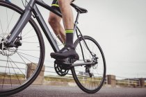 Low section of male athlete riding bicycle — Stock Photo