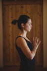 Жінка практикує йогу в фітнес-студії, вид збоку — стокове фото