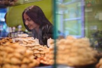 Mulher bonita olhando para doces turcos em exposição na loja — Fotografia de Stock