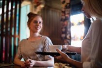 Офіціантка, що подає каву жінці в барі — стокове фото