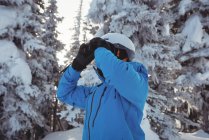 Esquiador mirando la montaña a través de binocular - foto de stock
