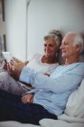 Seniorenpaar mit digitalem Tablet auf Bett im Schlafzimmer — Stockfoto
