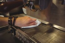 Close-up de garçonete limpando máquina de café expresso com guardanapo no café — Fotografia de Stock