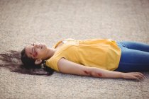 Крупный план бессознательной женщины, упавшей на землю после аварии — стоковое фото