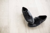 Par de sapatos de dança no chão de madeira no estúdio de dança — Fotografia de Stock