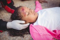 Paramédicos examinando menina ferida na rua — Fotografia de Stock