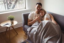 Romantic couple relaxing on sofa in living room at home — Stock Photo