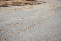 Primo piano della pista dei pneumatici sul fondo stradale in cemento — Foto stock