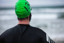 Rear view of athlete in wet suit standing — Stock Photo