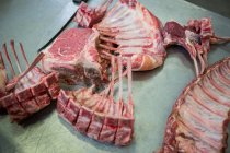 Крупный план мясных ребер и ножа на металлическом столе — стоковое фото