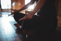 Vista cortada de mulher meditando fazendo mudra no estúdio de ioga — Fotografia de Stock