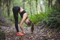 Frau macht Stretchübung im Wald — Stockfoto