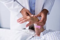 Arzt untersucht Puls der Patienten im Krankenhauszimmer — Stockfoto