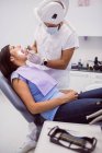 Стоматолог вивчає жіночі зуби пацієнта в клініці — стокове фото