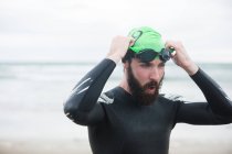 Крупный план спортсмена в плавательных очках на пляже — стоковое фото