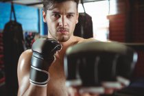 Portrait of boxer performing boxing stance in fitness studio — Stock Photo