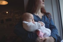 Mère tenant bébé mignon dans les bras au café — Photo de stock
