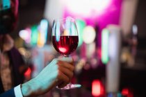Mão de homem de negócios segurando copo de vinho no bar — Fotografia de Stock
