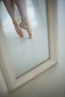 Mirror reflection of ballerina feet practicing ballet dance in studio — Stock Photo