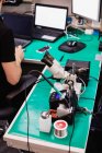Microscopio industrial y soldador con soldadura en un centro de reparación - foto de stock