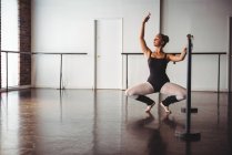 Ballerina übt Ballettschritt an der Barre im Ballettstudio — Stockfoto