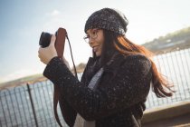 Улыбающаяся женщина фотографирует на цифровую камеру — стоковое фото