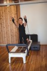 Donna che pratica pilates sul riformatore in palestra — Foto stock