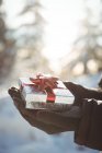 Close-up of male hands holding gift during winter — Stock Photo