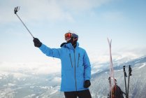 Skier taking selfie on snow covered mountain — Stock Photo