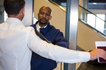 Security guard frisking passenger at airport terminal — Stock Photo