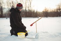 Primer plano del pescador de hielo que instala cebo en el equipo de pesca - foto de stock