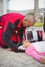 Парамедики осматривают раненую девушку на улице — стоковое фото