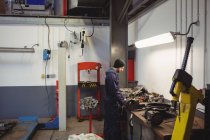 Mecánico de comprobación de un coche de piezas en el garaje de reparación - foto de stock