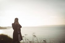 Женщина фотографирует на мобильный телефон в солнечный день — стоковое фото