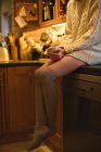 Retrato de mulher segurando uma xícara de café na cozinha em casa — Fotografia de Stock