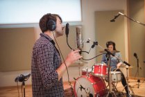 Uomo che canta al microfono in studio di registrazione — Foto stock