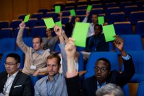 Business executives show their approval by raising hands at conference center — Stock Photo