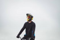Велогонщик сидит на велосипеде BMX в скейтпарке — стоковое фото
