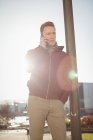 Чоловік-виконавчий виступ на мобільному телефоні на вулиці перед офісною будівлею — стокове фото