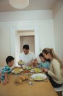 Família tendo refeição na mesa de jantar em casa — Fotografia de Stock