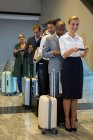 Пассажиры, стоящие в очереди у терминала аэропорта — стоковое фото
