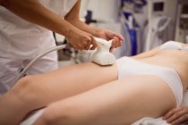 Женщина получает антицеллюлитное косметическое лечение в клинике, крупным планом — стоковое фото