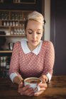 Frau mit Kaffeetasse im Café — Stockfoto