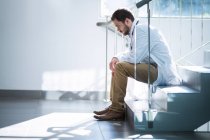 Сумний лікар сидить на сходах у лікарні — стокове фото