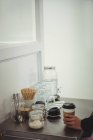 Mantener una taza de café en la mesa de acero en la cafetería - foto de stock