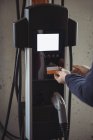 Человек с помощью подключаемой электрической машины на электростанции зарядки транспортного средства — стоковое фото