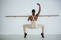 Veduta posteriore del ballerino che pratica danza classica in studio — Foto stock