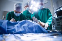 Grupo de cirurgiões que realizam operação no teatro de operação do hospital — Fotografia de Stock